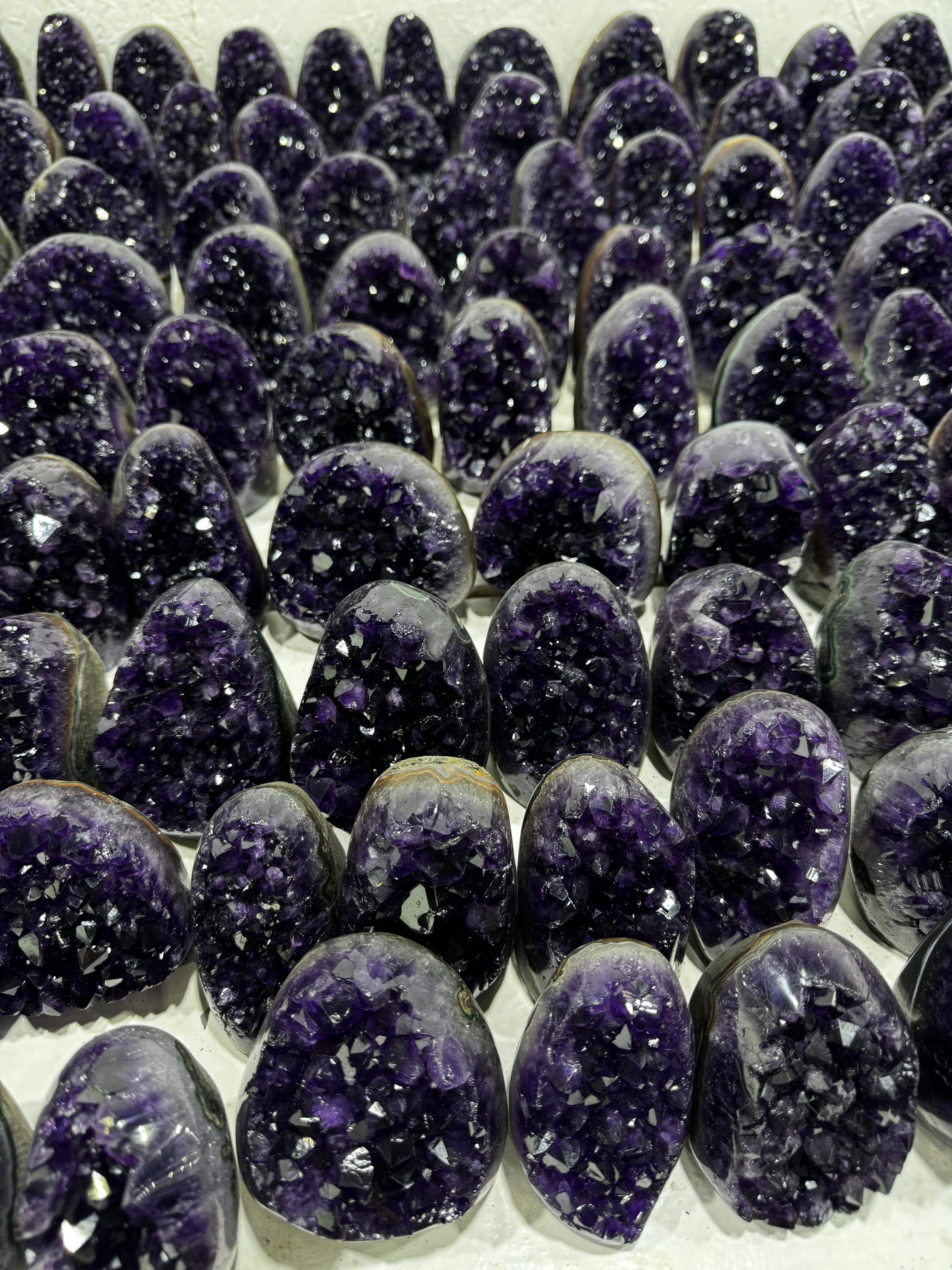 Rows of amethyst geodes standing on a showroom table
