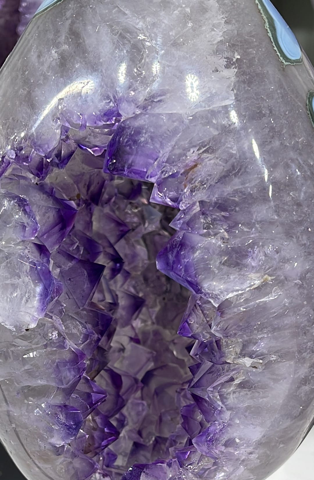 A polished amethyst piece with quartz, mounted on a base
