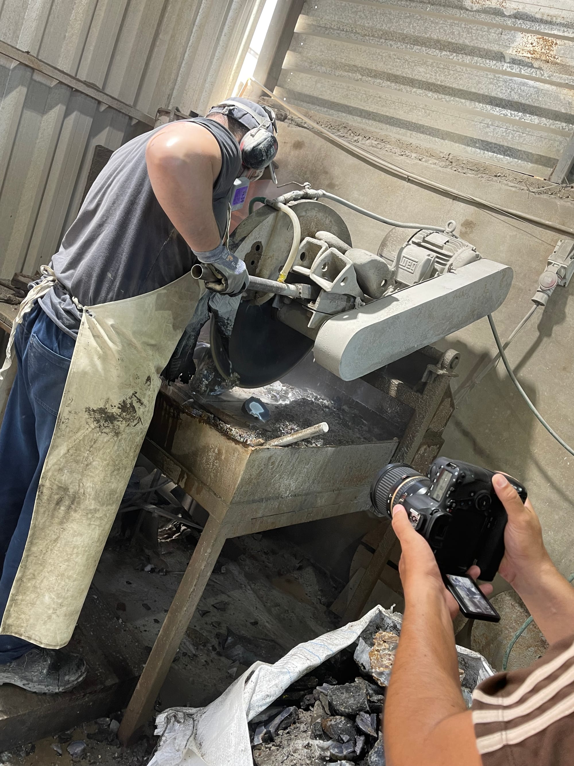 Un artesano corta una piedra con disco y agua en el taller