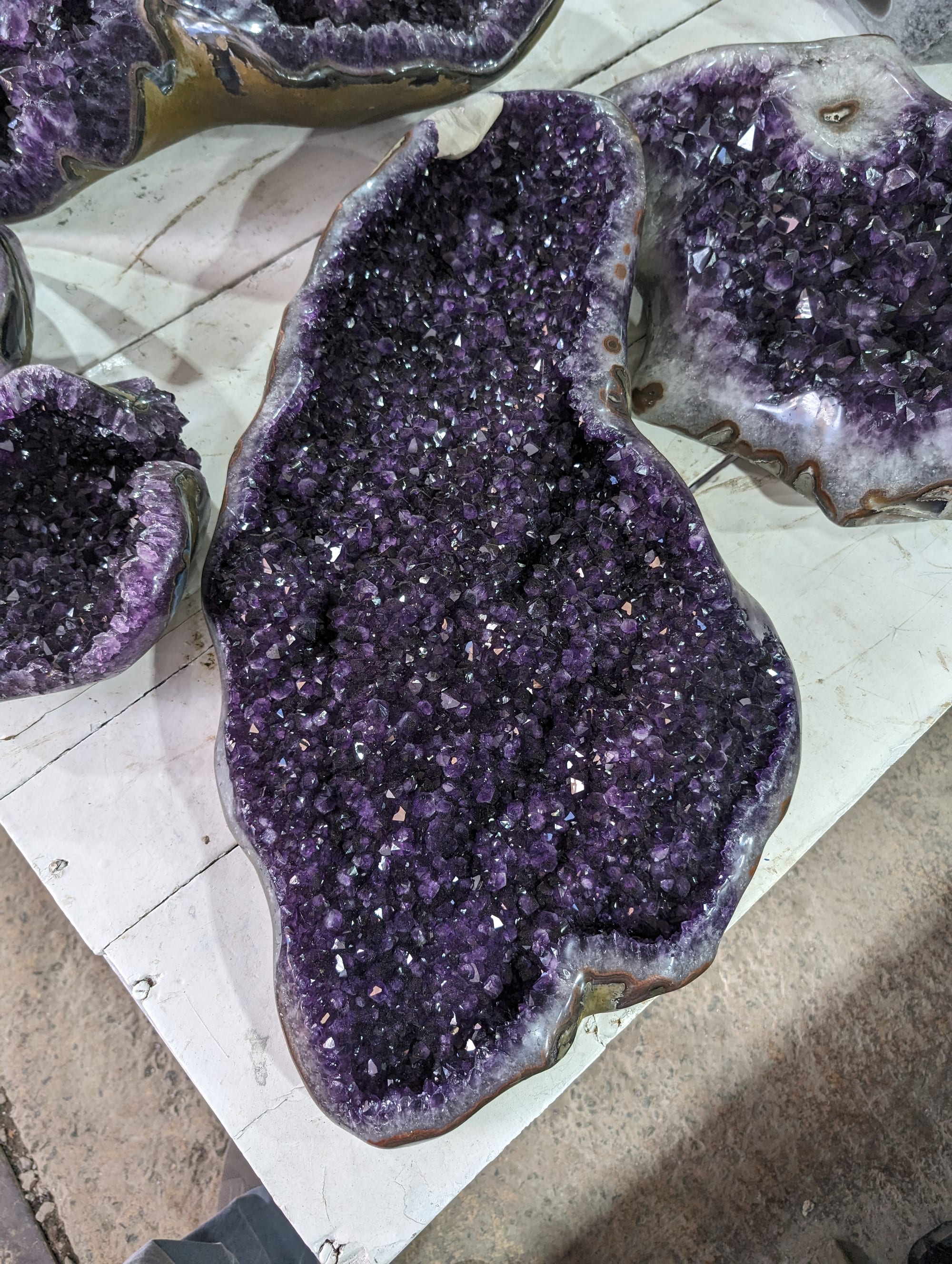 Amatista terminada en forma libre: una cavidad alargada cubierta de cristales violetas, con borde pulido