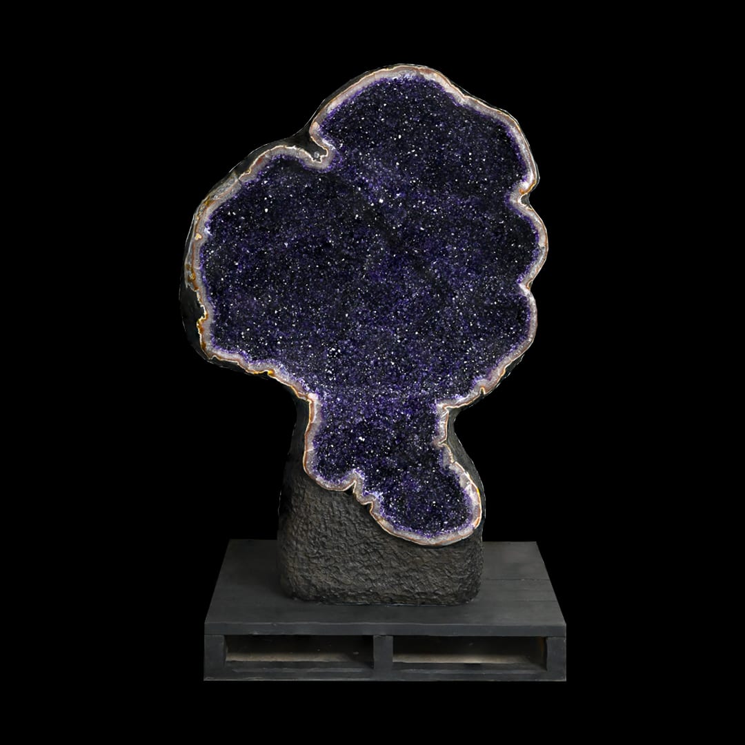 A lobed amethyst geode on a dark base