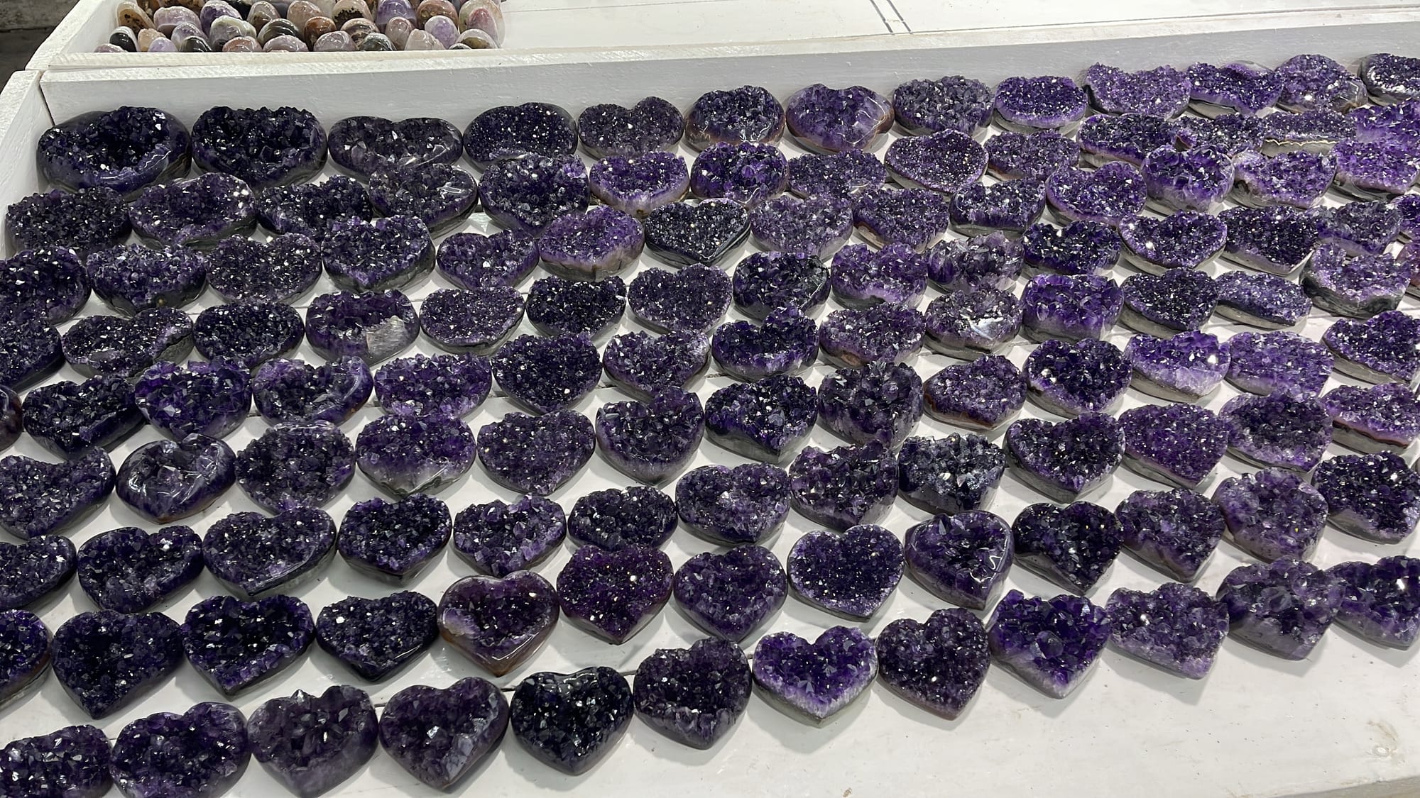 A lot of amethyst hearts arranged on a table